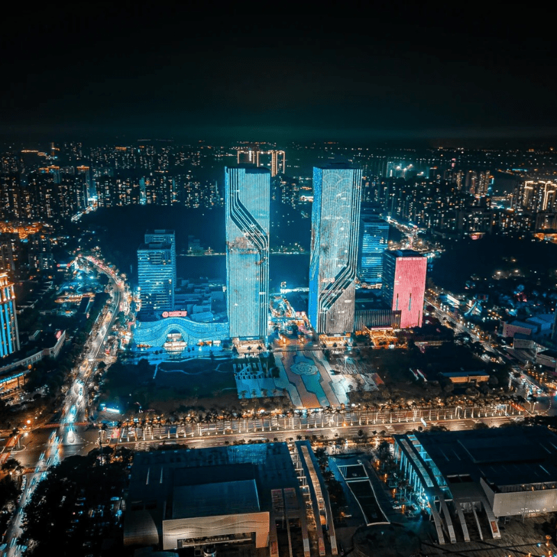 Night view of Jiangmen CBD with illuminated skyscrapers and city lights.