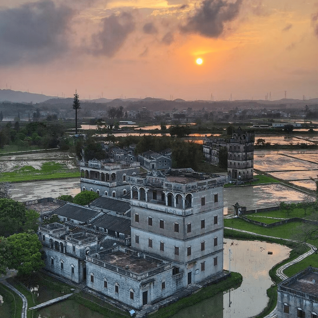 Zilicun Residential Kaiping Diaolou at sunset in Kaiping, surrounded by rice paddies and waterways