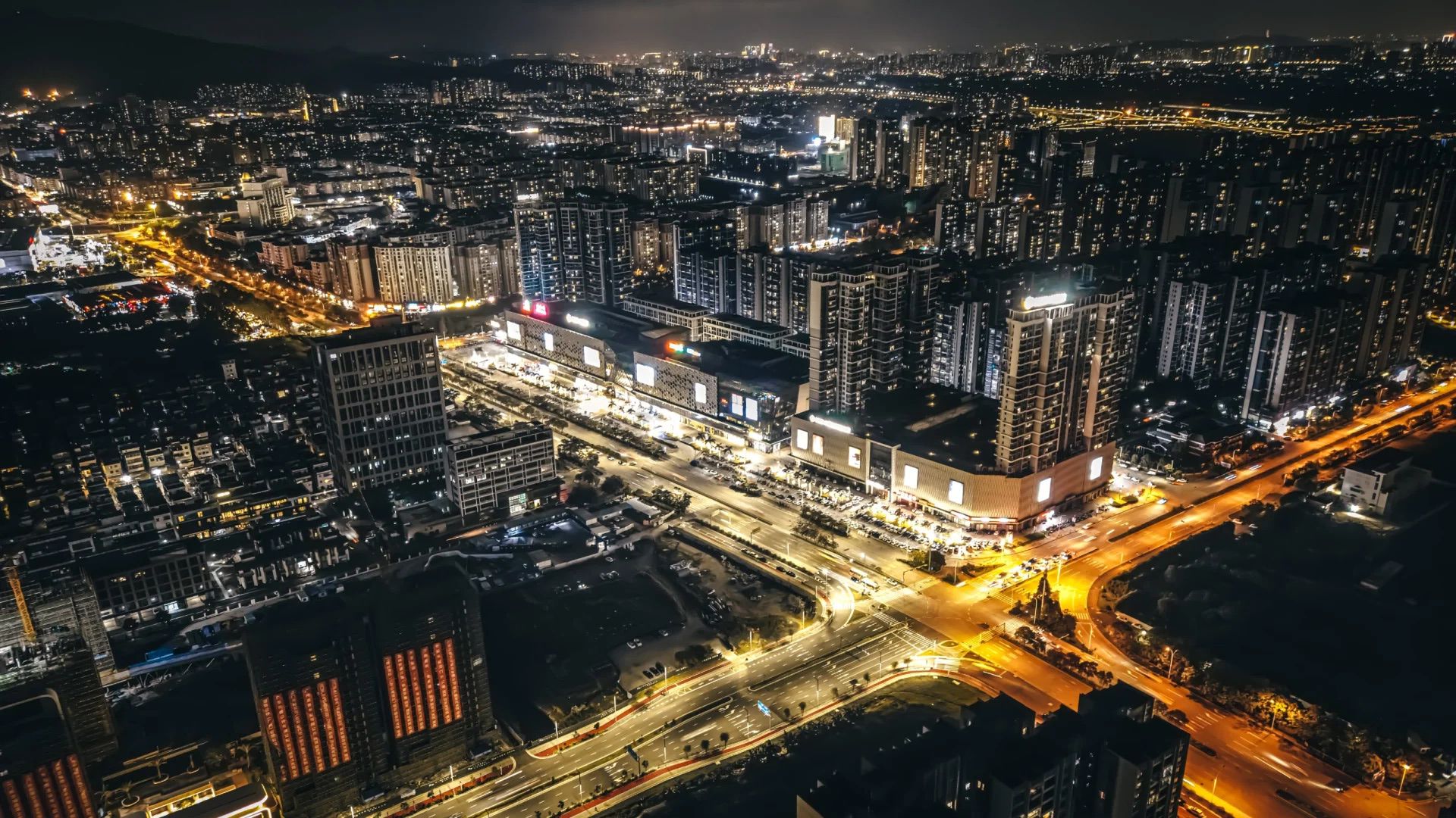 Aerial view of Xinhui city at night with bright lights and bustling streets.