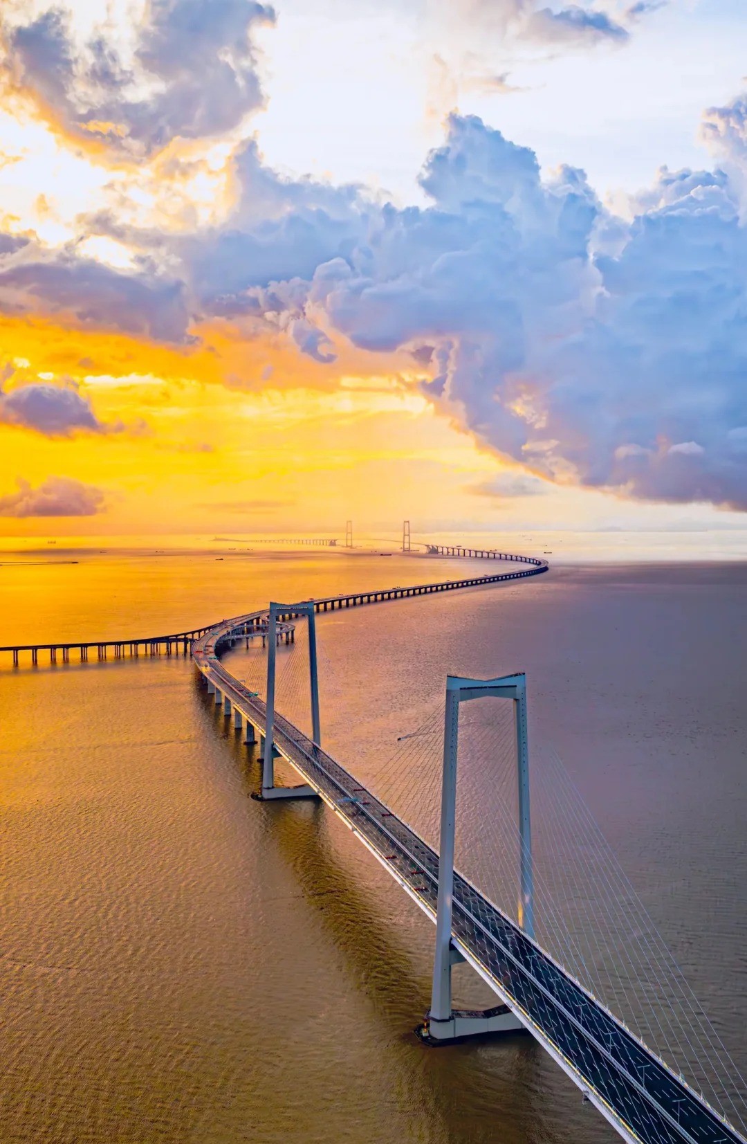 The Hong Kong-Zhuhai-Macau Bridge stretching across the sea at sunrise, representing connectivity in the Siyi Greater Bay Area.