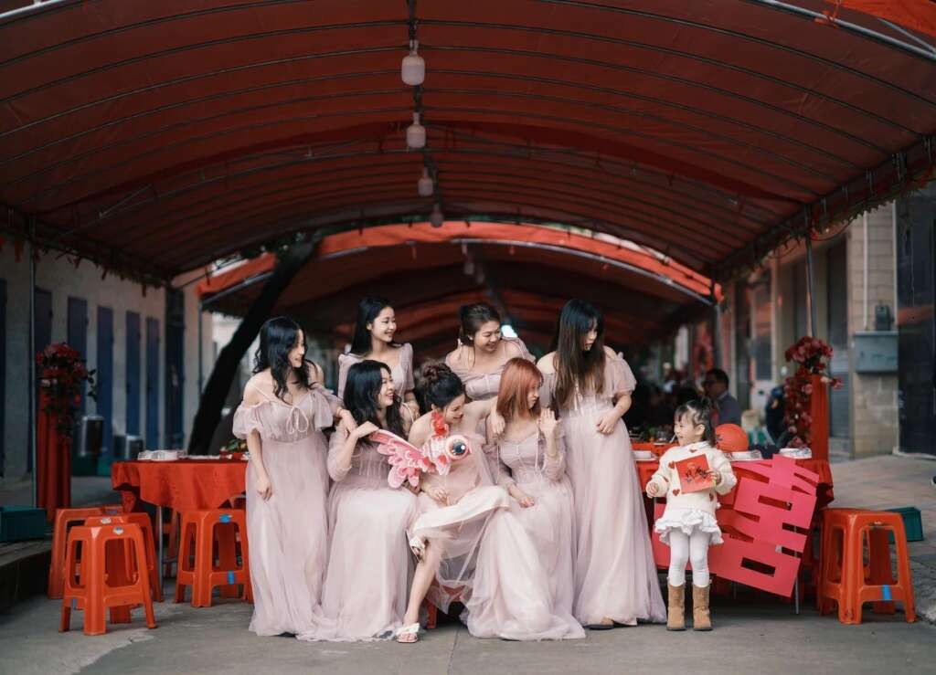 Bridesmaids and a child playing at a rural Chinese wedding, blending tradition with playful modernity